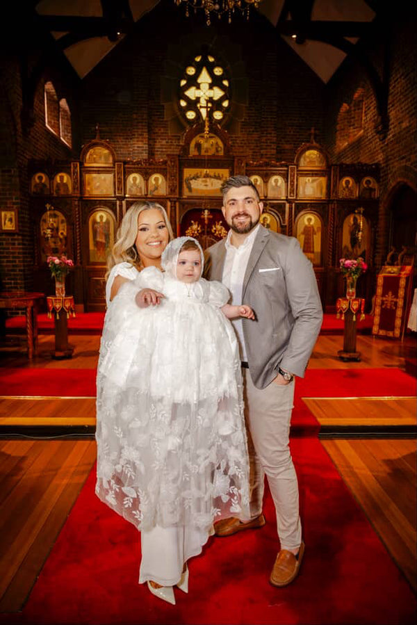 Family of three in a church setting with a red carpet