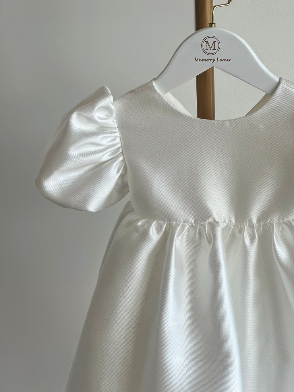 White dress on a hanger against a plain background